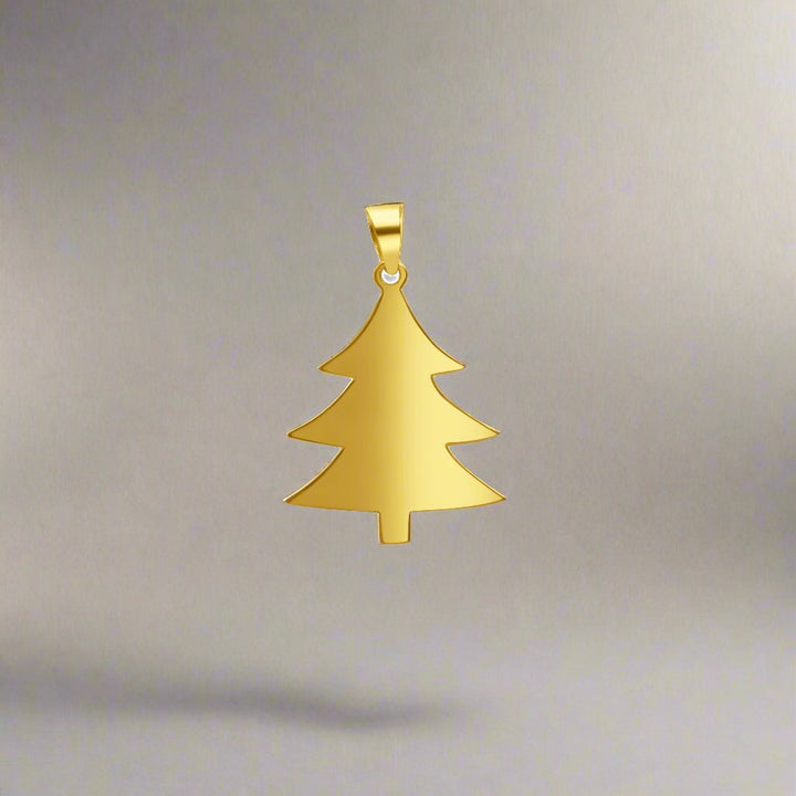 Elegant gold Christmas tree pendant featuring a minimalist design with smooth, polished edges and a sleek silhouette. The pendant is crafted in 18K gold and shaped like a classic fir tree, perfect for capturing the festive holiday spirit. It includes a small, secure loop for attaching to a chain, making it an ideal accessory for seasonal wear or gifting. Set against a neutral gray background, the design highlights the pendant's simplicity and timeless charm, making it a versatile addition to any jewelry col